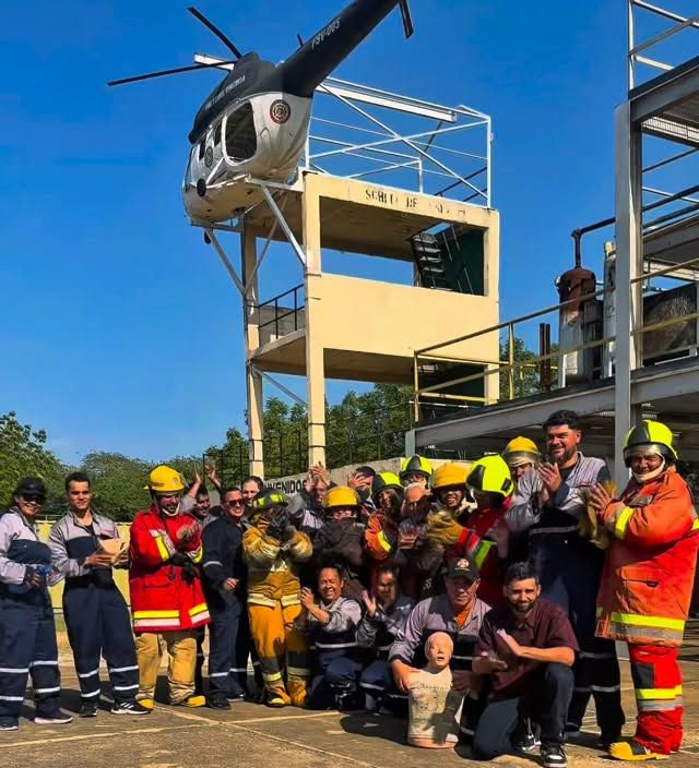 Grupo de brigadistas al terminar su curso frente a la torre de helicóptero